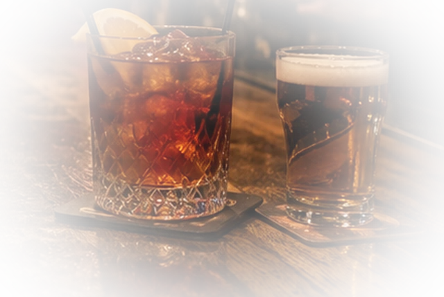 Cocktail und Bier auf der Holzbar der Destille