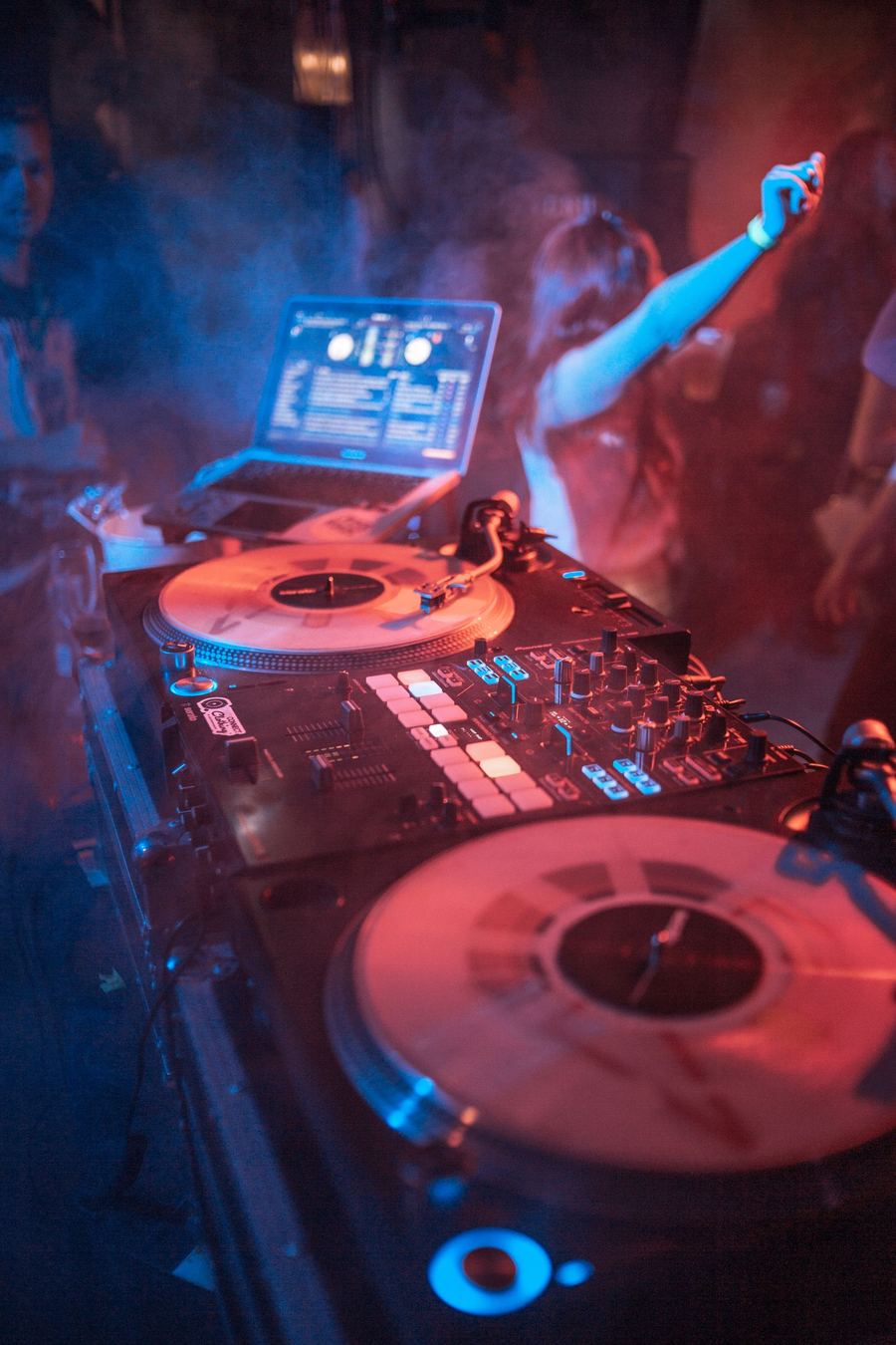 Symbolbild: DJ-Pult mit Vinyl-Turntables bei Partylicht