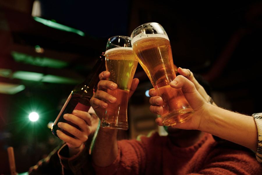 Symbolbild: Freunde stoßen in geselliger Bar-Atmosphäre an
